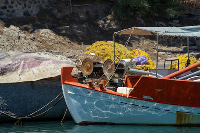 Colorful greek fishing boat and nets in a pier on santorini, greece.