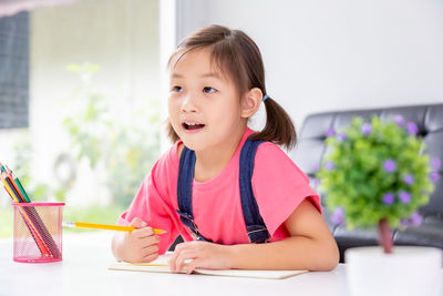 Portrait of cute girl sitting on table