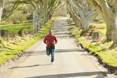 Full length of man cycling on dirt road