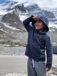 Boy standing on snow covered land