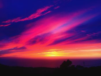 Scenic view of dramatic sky over silhouette landscape