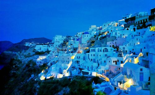 High angle view of illuminated buildings against blue sky