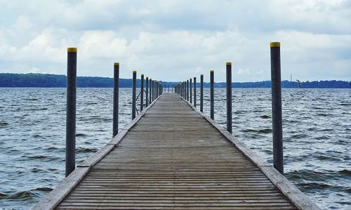 Wooden pier over sea against sky