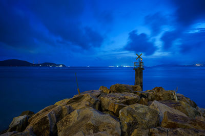 Lighthouse by sea against sky