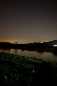 Scenic view of lake against sky at night