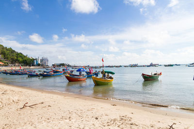 Boats moored on sea against sky