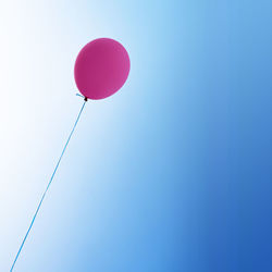 Low angle view of balloons against blue sky