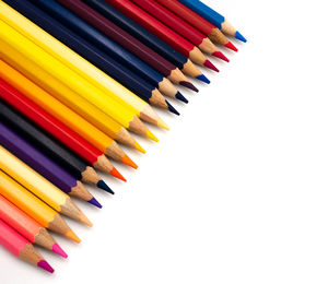 High angle view of multi colored pencils against white background