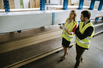 Man and woman in warehouse supervising stock