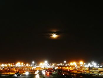 Illuminated buildings in city against sky at night