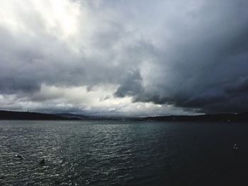 Scenic view of sea against storm clouds