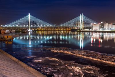 Suspension bridge over river at night