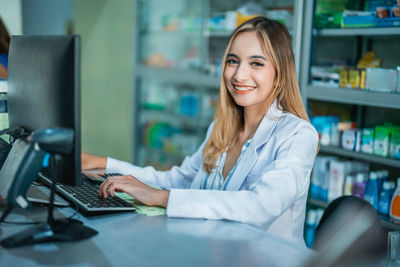 Businesswoman using laptop while sitting on table