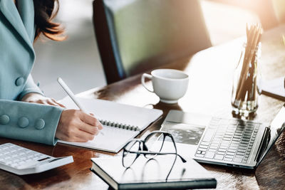 Midsection of businesswoman working on table