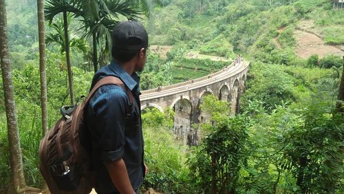 Man standing on bridge in forest