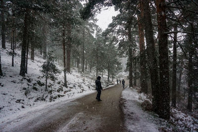Man standing on road at forest during winter