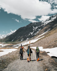 People on snowcapped mountain against sky