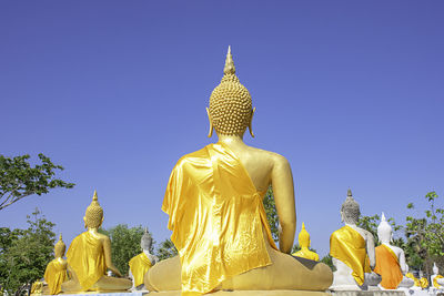 Low angle view of statue against temple against clear sky