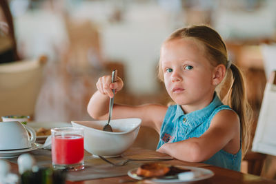 Portrait of cute girl eating breakfast at home