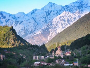 Scenic view of townscape and mountains against sky