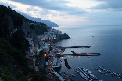 High angle view of city by sea against sky