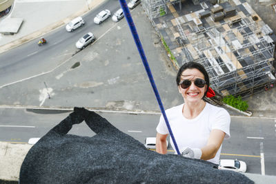 Caucasian woman wearing hero costume descending a tall building in rappel. salvador bahia brazil.