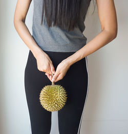 Midsection of woman standing against wall