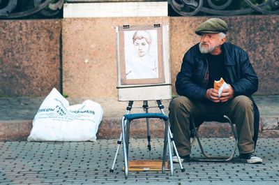 Rear view of woman sitting on wall