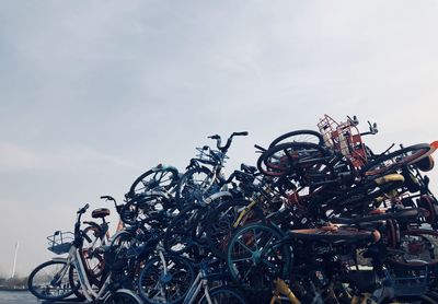 Bicycle parked in front of metal structure against sky