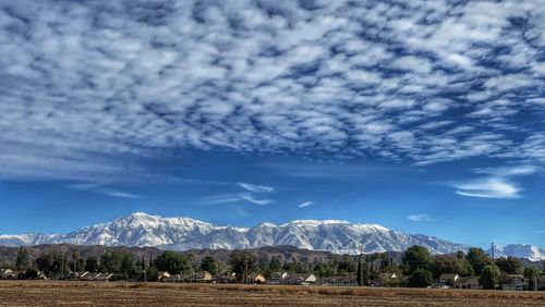 Scenic view of field and mountains against sky