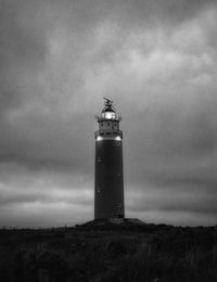 Low angle view of lighthouse on field against sky