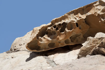 Low angle view of rock formation against clear blue sky