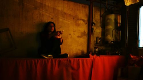 Young woman sitting in corridor