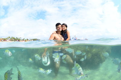 Father and daughter in sea against sky