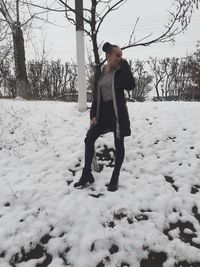 Full length of woman standing on field during winter