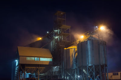 Low angle view of illuminated buildings against sky at night