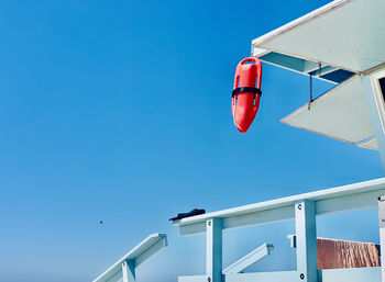 Low angle view of flag against clear blue sky