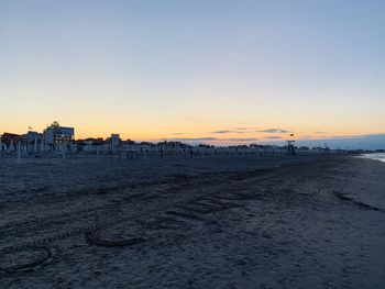 Scenic view of beach against clear sky during sunset