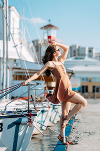 Woman with arms raised in city against sky