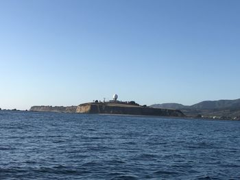 Buildings at waterfront against blue sky