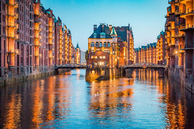 Bridge over canal amidst buildings in city