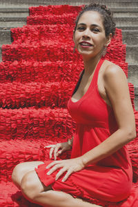 Portrait of a woman sitting on the red stairs. 