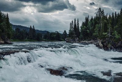 Scenic view of waterfall against sky