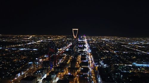 Illuminated cityscape against sky at night