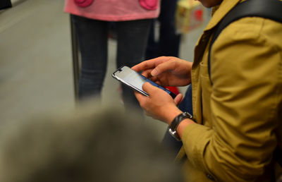 Midsection of man using mobile phone