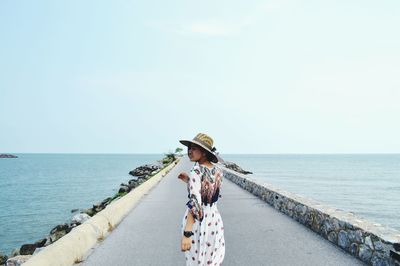 Rear view of person on sea against sky