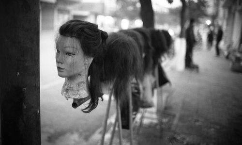 Close-up of mannequins with wig at street