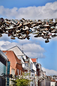 Low angle view of shoes hanging against buildings in city