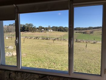 Scenic view of field seen through window