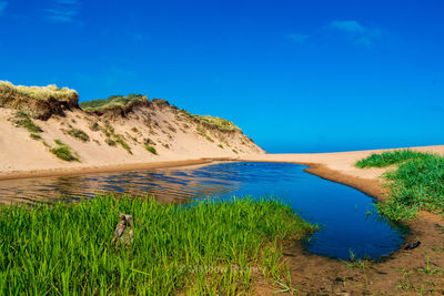 Scenic view of land against blue sky